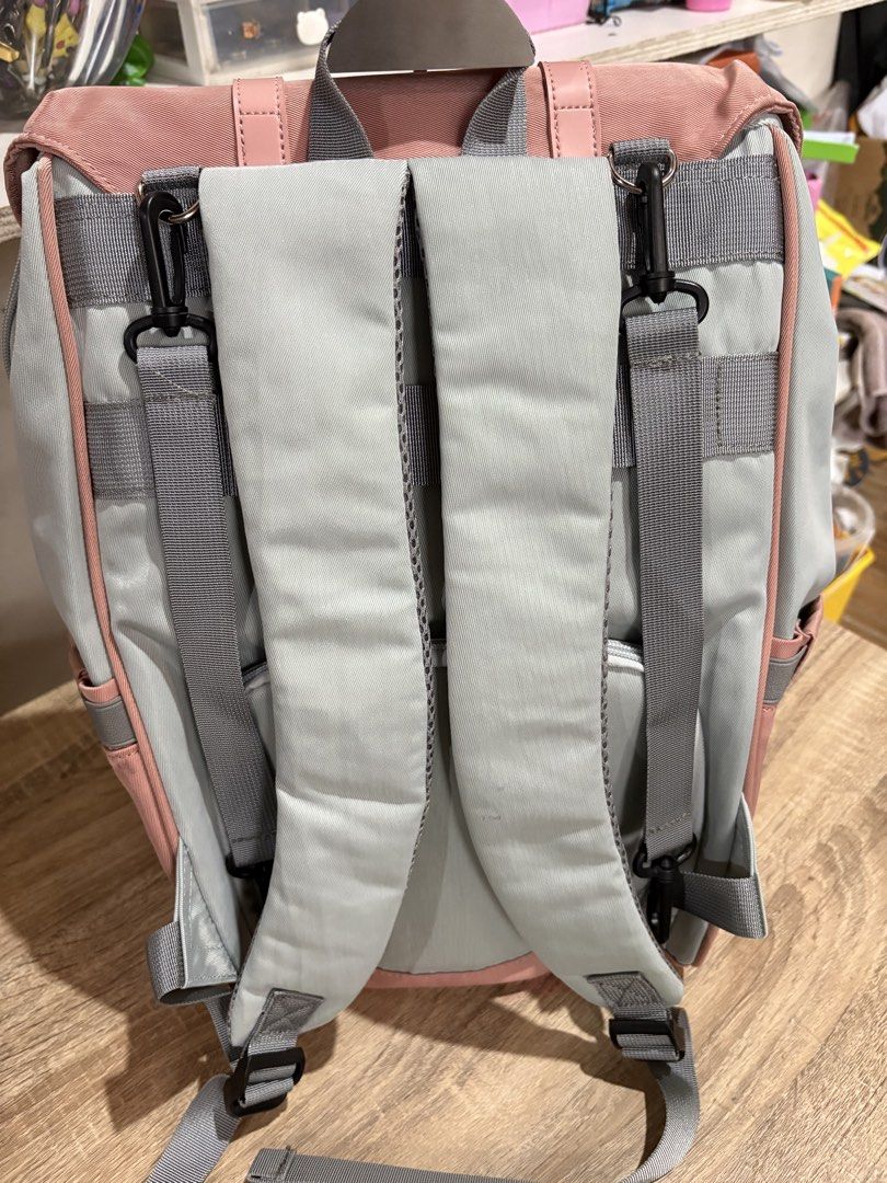 Mommy bag (Category: Babies & Kids Fashion) located in Pototan. Submitted by tres_190725 (Listing ID 1462105243, Image 2). Description: This is a pink and light blue multi-pocket casual backpack featuring dual decorative buckle straps across the front flap..