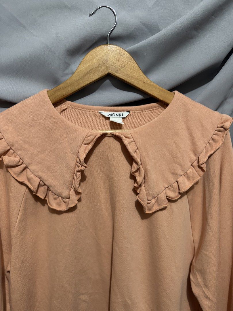 MONKL Peach Oversized Sweatshirt with Ruffle Collar (Category: Longsleeves) located in La Trinidad. Submitted by rare_closet_finds (Listing ID 1462070919, Image 2). Description: - Cute peach sweatshirt from MONKL -NOT faded -armpit to armpit 22” -length 22” - Features a large ruffle collar detail -size M on tag - Long sleeves with elasticated cuffs - Comfortable and stylish for casual wear.