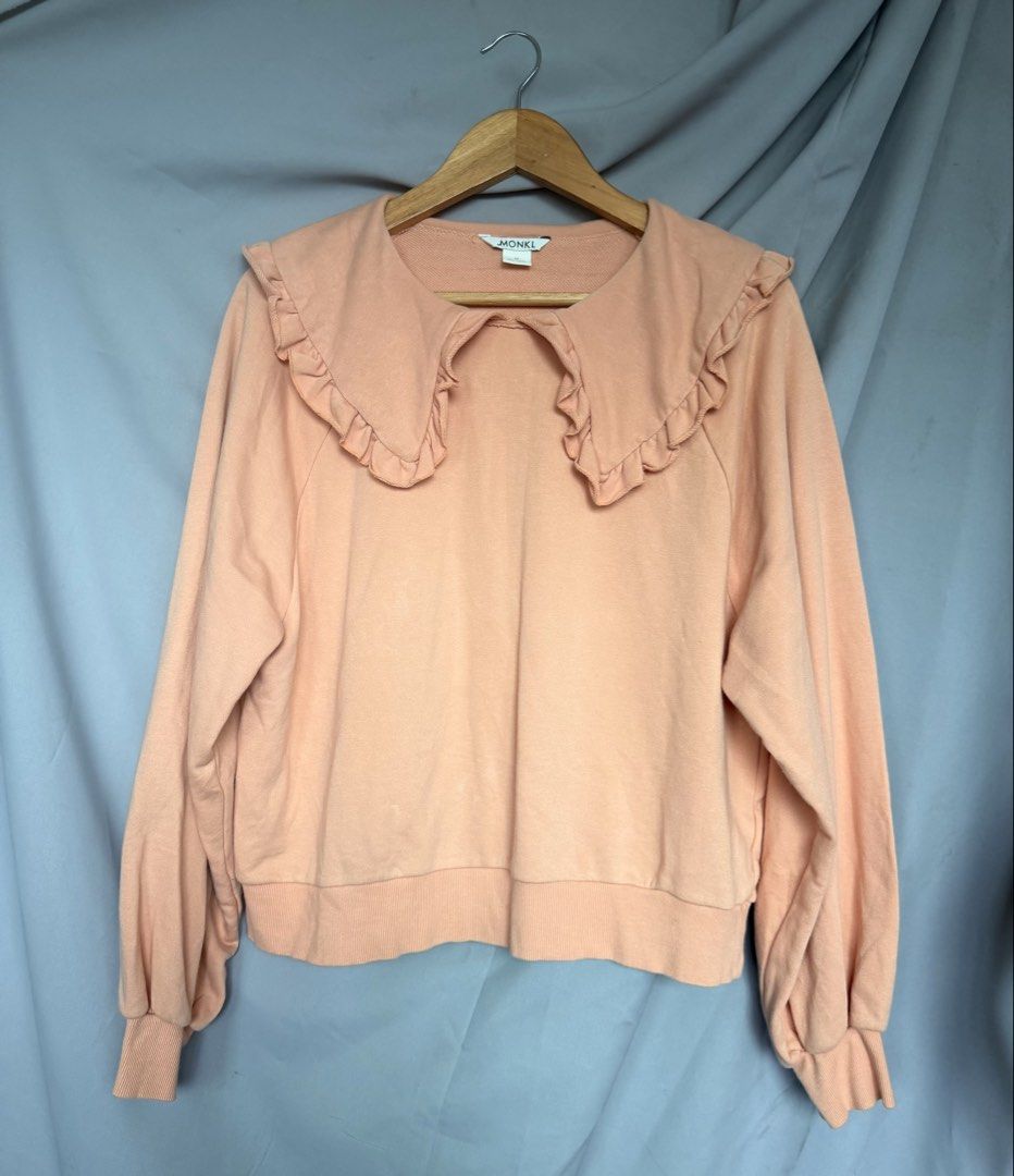 MONKL Peach Oversized Sweatshirt with Ruffle Collar (Category: Longsleeves) located in La Trinidad. Submitted by rare_closet_finds (Listing ID 1462070919, Image 3). Description: - Cute peach sweatshirt from MONKL -NOT faded -armpit to armpit 22” -length 22” - Features a large ruffle collar detail -size M on tag - Long sleeves with elasticated cuffs - Comfortable and stylish for casual wear.