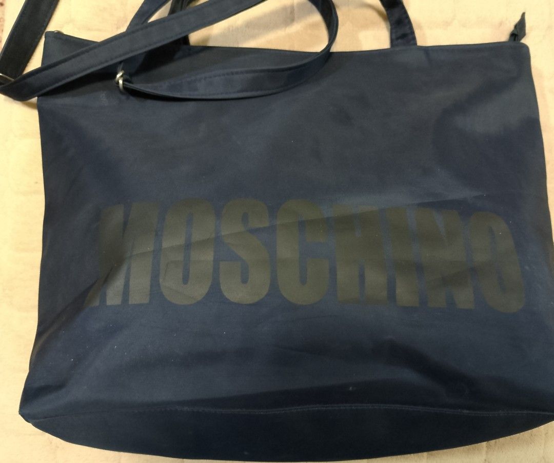 Moschino nylon bag (Category: Shoulder Bags) located in Caloocan City. Submitted by pvaliao (Listing ID 1462079320, Image 2). Description: Moschino nylon bag Brand: Moschino Price: 150 Color: Black Size: 17 inches × 12 inches Material: crafted from a durable , weather resistant nylon shell that offers a slouchy silhouette and easy cleaning. Pre-owned Design: features a classic black color with a subtle printed Moschino branding text graphic cente