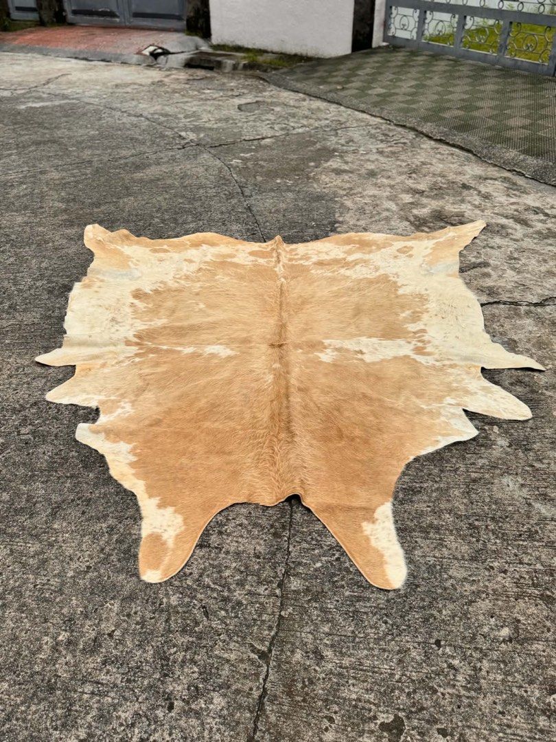 Natural Cowhide Rug - Unique Patchwork Design (Category: Carpets, Mats & Flooring) located in Manila. Submitted by jaderockoff (Listing ID 1462206454, Image 1). Description: - Authentic cowhide rug - Natural brown and white patchwork pattern - Adds a rustic vibe to any room - Perfect for living areas or bedrooms - Each rug has a unique shape and markings.