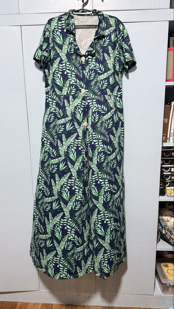 Navy Blue Tropical Leaf Print Button-Up Maxi Dress (Category: Dresses) located in Quezon City. Submitted by amogz (Listing ID 1462087557, Image 1). Description: - Navy blue maxi dress - Vibrant green tropical leaf print - Short sleeves - Collared neckline - Fake Button-up front with wooden-look buttons - Ideal for casual outings or beach vacations - Comfortable and stylish.