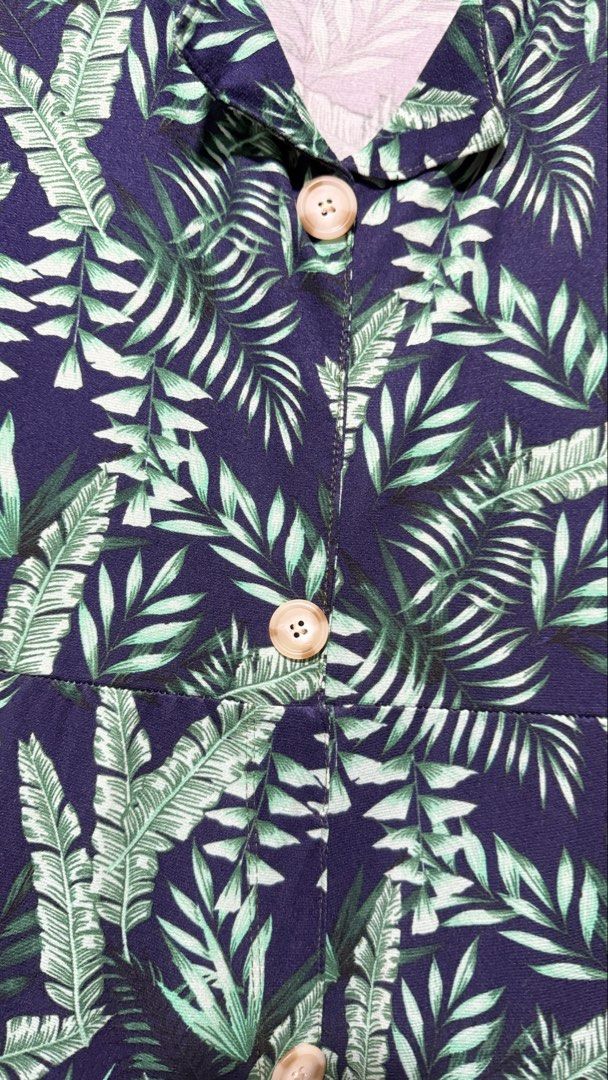 Navy Blue Tropical Leaf Print Button-Up Maxi Dress (Category: Dresses) located in Quezon City. Submitted by amogz (Listing ID 1462087557, Image 2). Description: - Navy blue maxi dress - Vibrant green tropical leaf print - Short sleeves - Collared neckline - Fake Button-up front with wooden-look buttons - Ideal for casual outings or beach vacations - Comfortable and stylish.