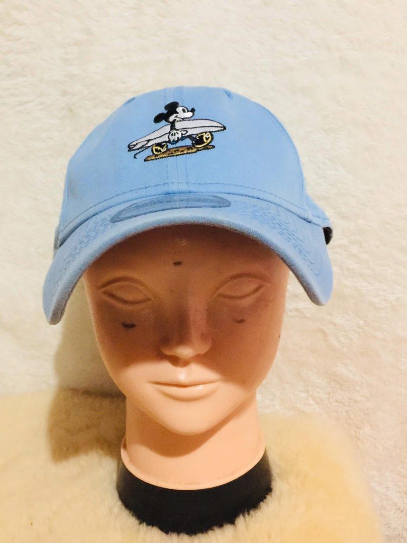 New Era 9FORTY Mickey Mouse Surfing Cap Light Blue Adjustable (Category: Caps & Hats) located in Baguio. Submitted by izza_thrifty (Listing ID 1462062719, Image 2). Description: - Light blue New Era 9FORTY cap - Features a cute surfing Mickey Mouse graphic - Adjustable strap at the back for a comfortable fit - Iconic New Era logo embroidered on the side - Ideal for casual outings and Disney enthusiasts.
