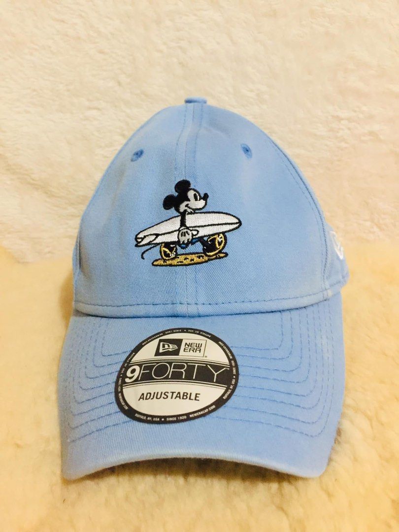 New Era 9FORTY Mickey Mouse Surfing Cap Light Blue Adjustable (Category: Caps & Hats) located in Baguio. Submitted by izza_thrifty (Listing ID 1462062719, Image 1). Description: - Light blue New Era 9FORTY cap - Features a cute surfing Mickey Mouse graphic - Adjustable strap at the back for a comfortable fit - Iconic New Era logo embroidered on the side - Ideal for casual outings and Disney enthusiasts.