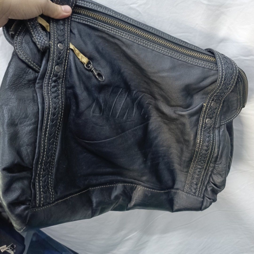 Nike Leather Shoulder Bag (Category: Shoulder Bags) located in Pasay City. Submitted by joanirishb86535 (Listing ID 1462121769, Image 2). Description: - Genuine black leather Nike shoulder bag - Features embossed Nike logo on the front - Stylish braided details on straps and sides - Secure zipper closure - Interior includes a zip pocket and a mesh pocket - Ideal for everyday use and carrying your essentials.