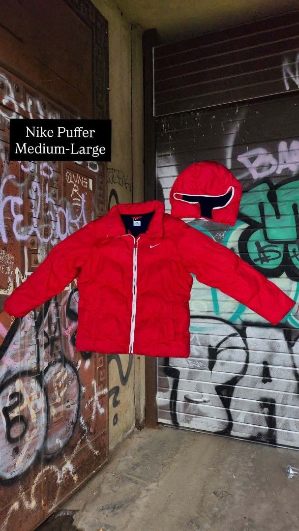 Nike Red Puffer Jacket with Hood - Medium-Large (Category: Coats, Jackets and Outerwear) located in Manila. Submitted by warmowl.9a2864 (Listing ID 1462216141, Image 1). Description: - Red Nike puffer jacket - Size: Medium-Large (M-L) - Detachable hood for versatile styling - Excellent for staying warm and cozy - Stylish white zipper with a contrasting design - Iconic Nike logo on the chest - Pre-loved and ready for a new home.