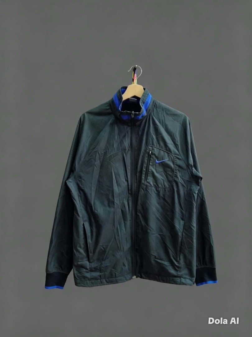 Nike Track Jacket Blue Collar Zip Up (Category: Coats, Jackets and Outerwear) located in Alegria. Submitted by happypenguin-d20d (Listing ID 1462079266, Image 1). Description: - Cool Nike track jacket - Dark grey with blue accents on collar and cuffs - Zippered chest pocket - Two side pockets - Great for casual wear or sports - Easy to zip up.