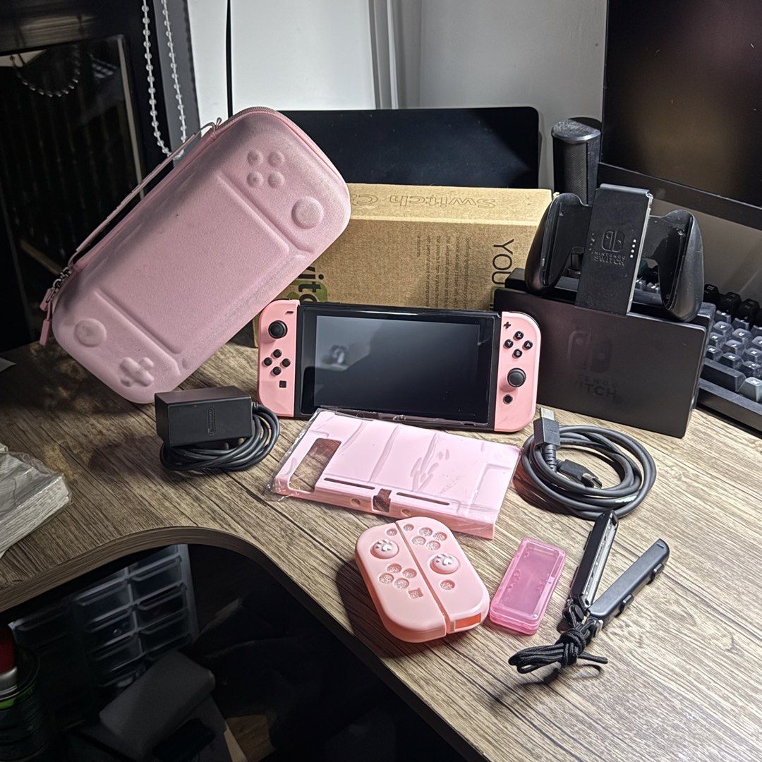 Nintendo Switch V2 complete Sakura Pink Set (Category: Nintendo) located in Quezon City. Submitted by consoleciety (Listing ID 1462222774, Image 1). Description: Selling Nintendo Switch V2 complete for ₱10,499 Sakura Pink setup 🥹 —presentable, 9.6/10 cosmetics condition | tempered glass installed —no issue, everything working & checked according to my guide (posted on black app) —original pastel pink joycons worth ~4K —complete accessories (no b