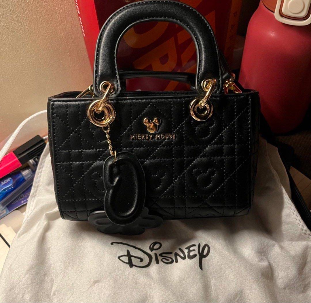 (NO ISSUE, AUTHENTIC) Black Mickey Mouse Quilted sling/hand bag (Category: Shoulder Bags) located in Manila. Submitted by solvithrifts (Listing ID 1462205586, Image 1). Description: - Cute black top handle bag - Features adorable Mickey Mouse quilting - Elegant gold hardware - Versatile chain strap - Comes with a charming Mickey Mouse accessory - Interior zip pocket for essentials - Disney branded dust bag included - Ideal gift for any Disney ent