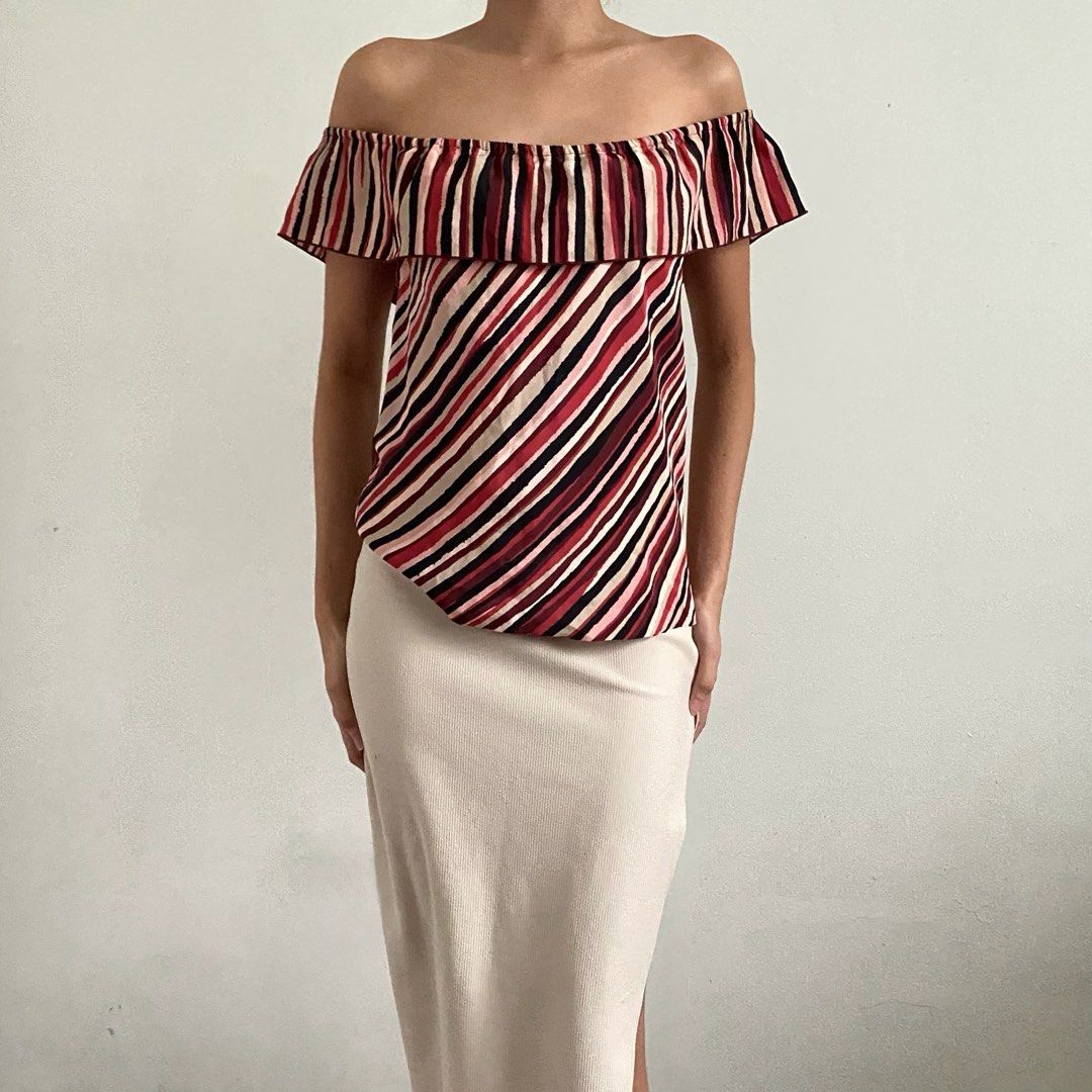 Off Shoulder Striped Ruffle Top (Category: Blouses) located in Tarlac. Submitted by luv__vintage (Listing ID 1462259597, Image 1). Description: - Cute off-shoulder design - Ruffle detail for added flair - Bold striped pattern (red, black, beige) - Fabric with a slight sheen - Versatile: pairs well with skirts or high-waisted pants - Ideal for night outs or casual wear.
