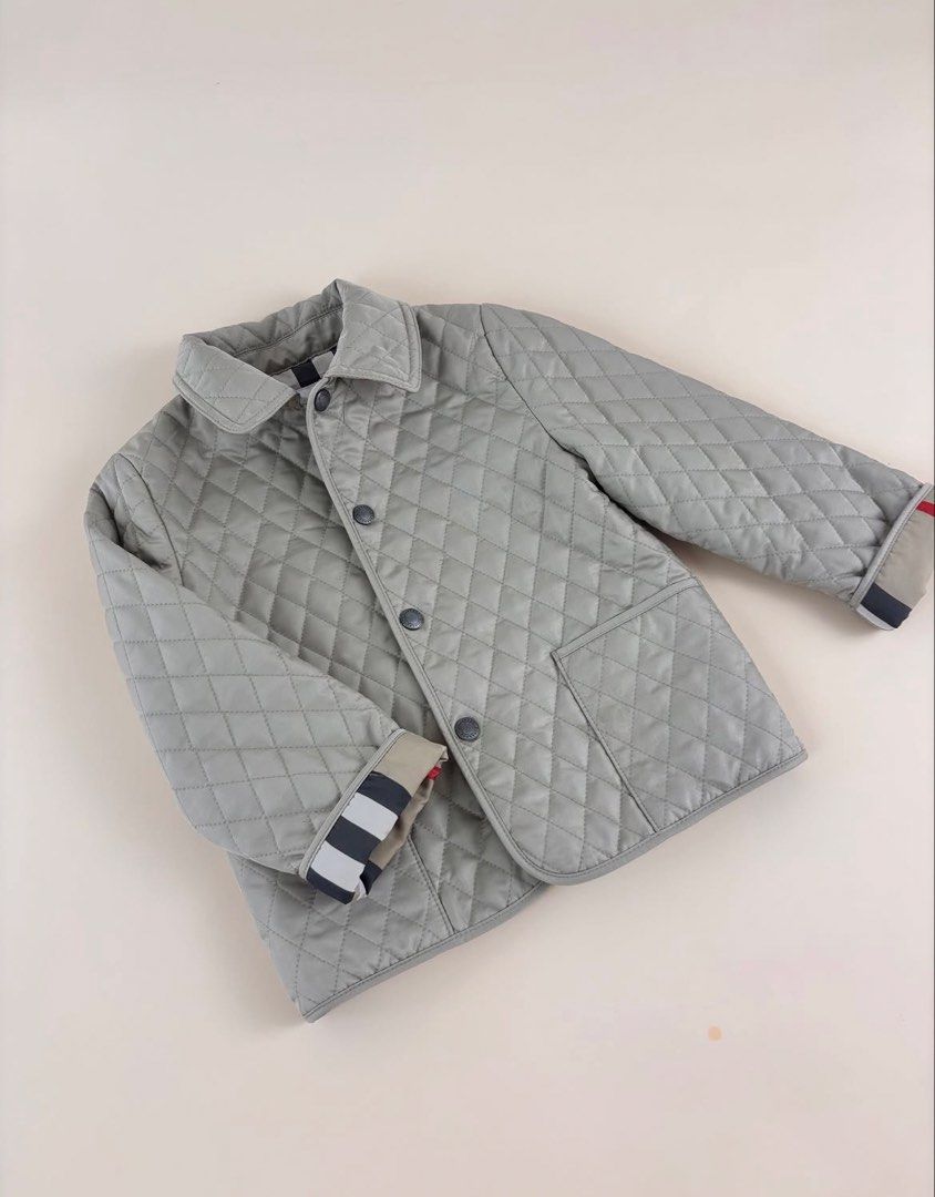 Original Burberry Childrens Quilted Jacket (Category: Babies & Kids Fashion) located in Cavite. Submitted by trendytop (Listing ID 1462043296, Image 2). Description: - Light grey quilted jacket for kids - Classic Burberry check lining - Button front closure - Two functional pockets - Signature Burberry stripe detail on cuffs - Ideal for cooler weather -Unisex -Bought 10k + in store.
