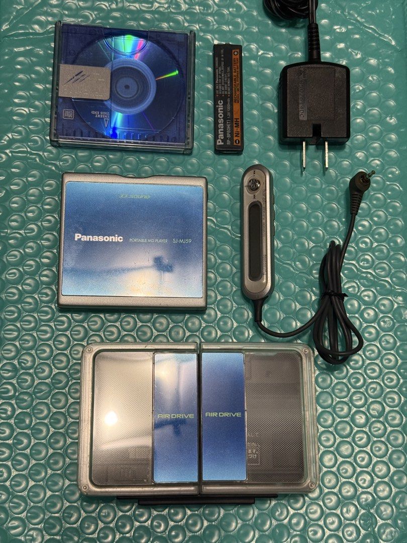 Panasonic Minidisc Player SJ-MJ59 with Speaker (Category: Portable Music Players) located in Makati City. Submitted by see5o5 (Listing ID 1462049854, Image 1). Description: - Panasonic MD portable MiniDisc player SJ-MJ59 - Tested and working (needs a new battery) - Includes: Air Drive speaker/charging dock, AC Adapter (100v), remote control - Also comes with one MiniDisc and the original Panasonic battery that needs to be replaced. This is over 2
