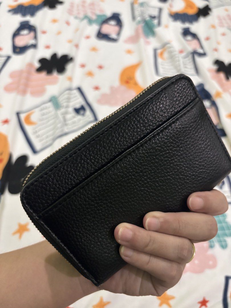 Parfois Black Leather Zip Around Wallet (Category: Wallets & Card holders) located in Rizal. Submitted by youronlineshoppe (Listing ID 1462181075, Image 2). Description: - Sleek black leather wallet - Secure zip-around closure - Multiple card slots for organization - Clear ID window for easy access - Convenient zippered coin pocket - Stylish textured exterior - Elegant small gold logo accent - Compact and practical for everyday use.