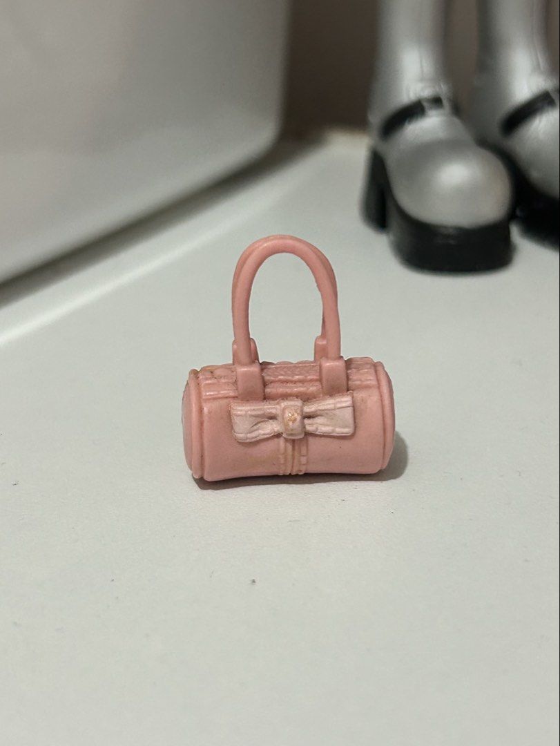 Pink Barrel Handbag Accessory for Dolls (Category: Purses & Pouches) located in Batangas. Submitted by nommi26 (Listing ID 1462199609, Image 1). Description: - Adorable pink barrel-shaped handbag. - Needs cleaning - Features a charming bow detail on the front. - Perfectly sized for fashion dolls. - A must-have accessory to complete any doll's look. - Adds a vibrant pop of color to outfits..