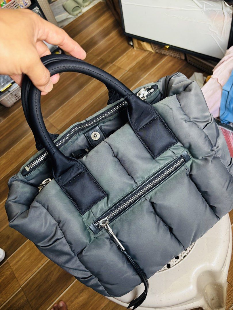 Prada Nylon Puffer Tote Bag Grey (Category: Luxury Bags & Wallets) located in Aroroy. Submitted by paldogs (Listing ID 1462109229, Image 2). Description: - Grey Prada nylon puffer tote - Genuine leather handles and trim - Secure zipper closure - Convenient front zip pocket - Multiple interior compartments for organization -DISCOLORATION - Sleek silver-tone hardware - Ideal everyday bag -NO SLING / STRAP -NO SNAP LOCK.