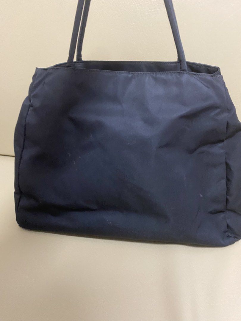 Prada Nylon Tote Bag (Category: Luxury Bags & Wallets) located in Agdangan. Submitted by aikara683 (Listing ID 1462053554, Image 3). Description: - Classic navy blue Prada tote bag - Made from durable nylon - Iconic Prada triangle logo on the front - Interior zippered pocket - Great for everyday use - Minor marks on exterior (please check photos).