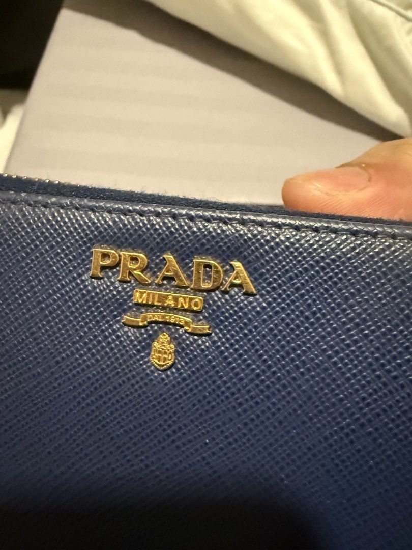 Prada Saffiano Leather Zip Around Wallet Navy Blue (Category: Luxury Bags & Wallets) located in Mandaluyong City. Submitted by huntervip (Listing ID 1462155234, Image 2). Description: - Authentic Prada wallet - Navy blue Saffiano leather - Gold hardware Prada logo - Includes original box, dust bag, and authenticity card - Secure zip-around closure - Plenty of space for cards and cash - Ideal for everyday use .