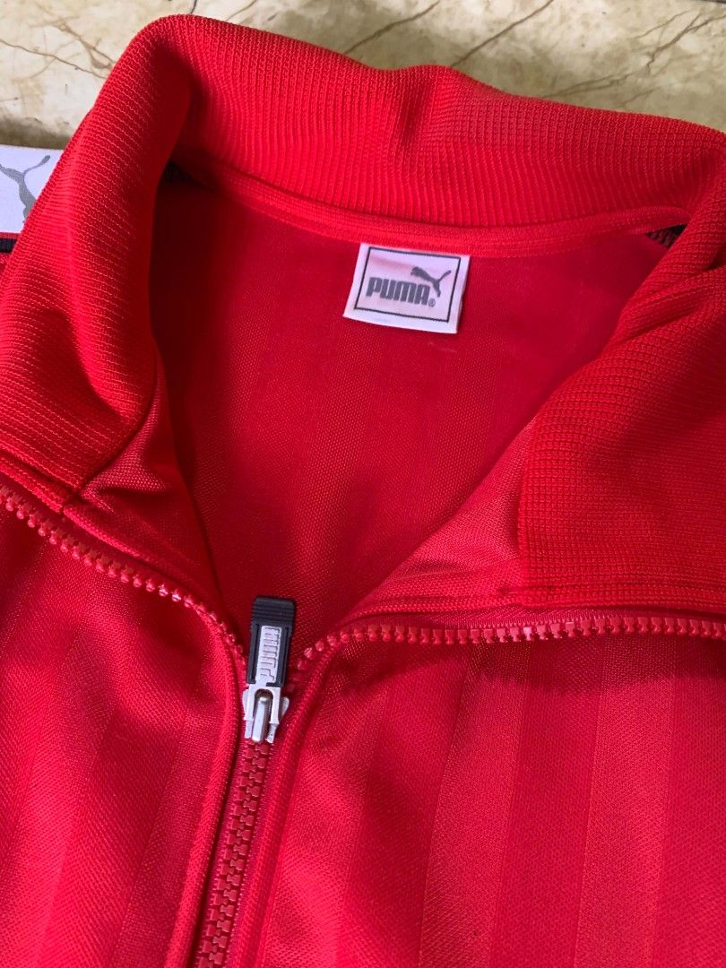 Puma Red Track Jacket (Category: Coats, Jackets and Outerwear) located in Quezon City. Submitted by chic.on.a.dime (Listing ID 1462069339, Image 3). Description: - NO ISSUE (MY PERSONAL JACKET, NOT UKAY) - WALANG BASAG PRINTS, LAHAT, AS IN, BAGONG BAGO - vintage Puma side-tape track jacket - Iconic Puma logo on chest and large logo on back - Striped detailing on sleeves with Puma branding - Full zip closure - Two front pockets - Ideal for casual 