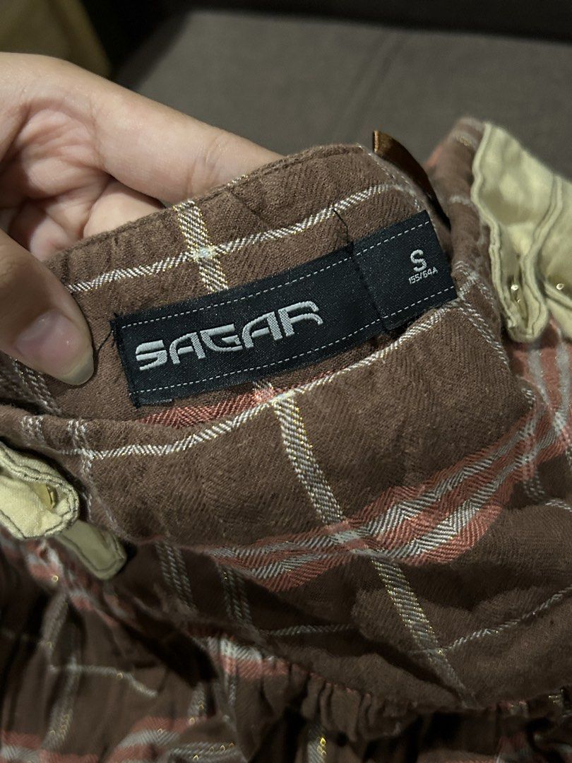 Sagar Plaid Ruffle Skirt Size S (Category: Skirts) located in Adams. Submitted by zencharm (Listing ID 1462226203, Image 2). Description: - Brown plaid skirt from Sagar - Size S - Ruffled hem with gold thread detail - Cute layered look - Versatile for casual or edgy outfits.