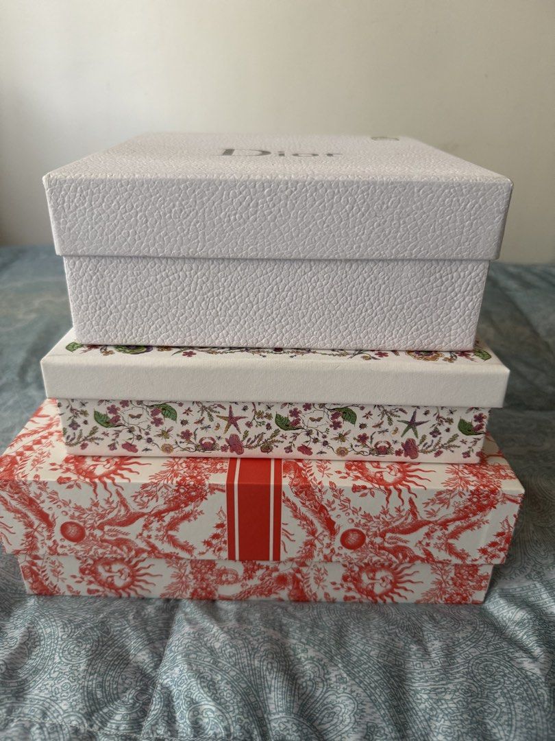 Set of 3 Christian Dior Boxes (Category: Luxury Accessories) located in Manila. Submitted by prelovedshop0818 (Listing ID 1462103865, Image 2). Description: - Set of 3 authentic Christian Dior gift boxes. - Includes one white textured box with 'Dior' logo. - One white box with intricate floral and coral design. - One red and white toile de jouy patterned box with 'Christian Dior' band. - Ideal for storing small valuables or as a collector's item.