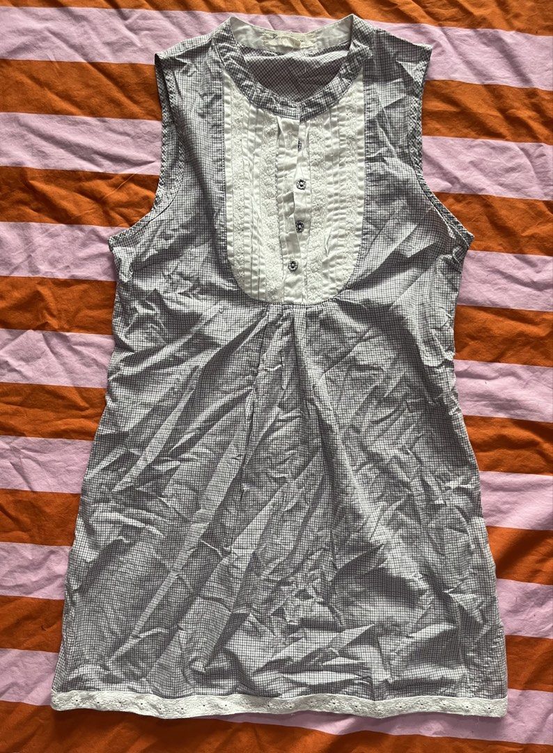 Sheer Gingham Sleeveless Blouse with Lace Trim (Category: Blouses) located in Mandaluyong City. Submitted by hopeworldplane (Listing ID 1462204022, Image 1). Description: - Sleeveless blouse - Gingham pattern - Ruffled lace detail down the front - Lace trim at the hem - Button closure at the neckline - Versatile for casual or dressy looks - Pairs well with jeans or skirts.