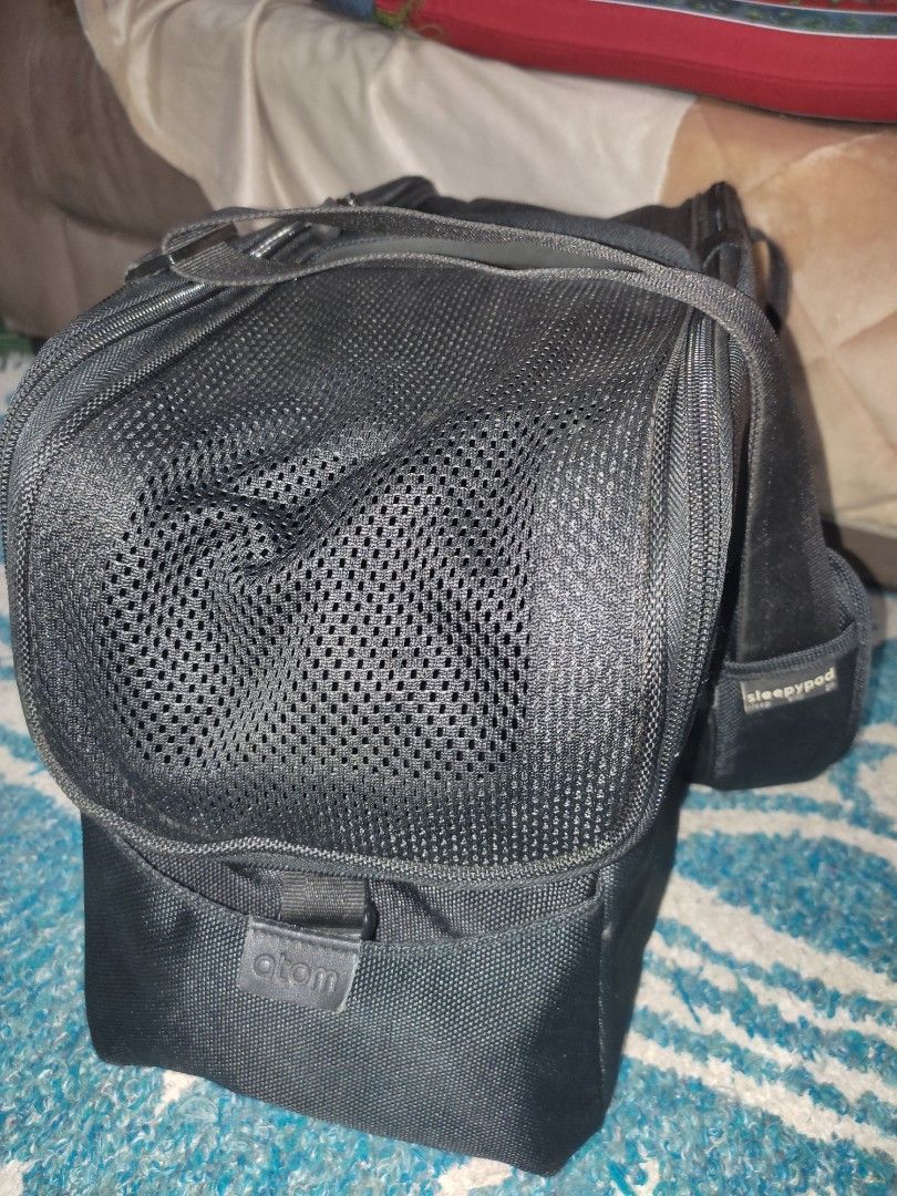 Sleepy Pod Pet carrier (Category: Camera Bags & Carriers) located in Cainta. Submitted by allauthenticbymj (Listing ID 1462066668, Image 2). Description: Unused pet carrier bag The item in the image is a black Sleepypod Atom pet carrier featuring a padded shoulder strap and branded logo tag. Modern airline-approved pet carrier designed to fit beneath a wide range of airline seats.Suitable for small pets up to 12 pounds, with side storage pockets 
