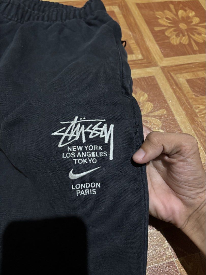 Stussy x Nike Sweatpants (Category: Joggers) located in Manila. Submitted by noribrahim.20 (Listing ID 1462118126, Image 2). Description: - Authentic Black Stussy x Nike Sweatpants - Iconic Stussy logo featuring global city names: New York, Los Angeles, Tokyo, London, Paris - Signature Nike swoosh detail - Convenient side zipper pockets - Comfortable elastic waistband and cuffs - Ideal for stylish and casual everyday wear.