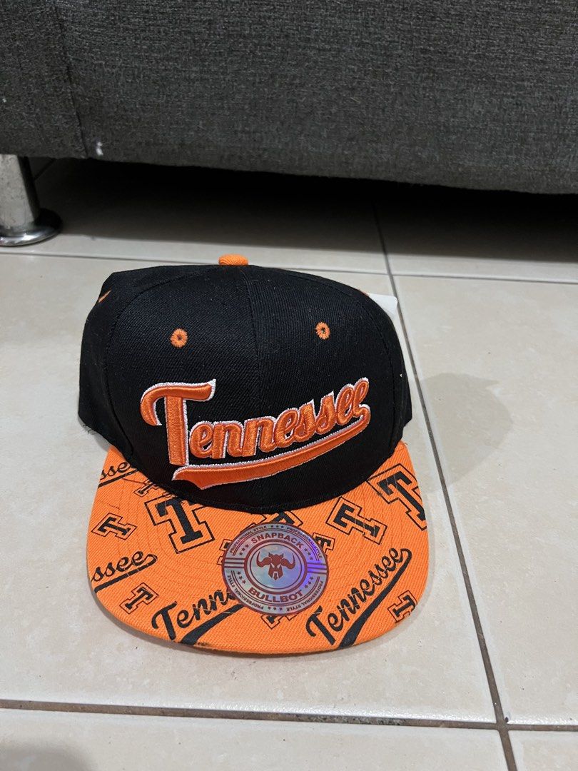 Tennessee Snapback Cap Orange Black Bull Boy (Category: Caps & Hats) located in Mandaluyong City. Submitted by luna_elisse (Listing ID 1462050867, Image 1). Description: - Orange and black snapback cap - 'Tennessee' embroidered on front and back - Repeating 'Tennessee' and 'T' pattern on brim - Adjustable snapback closure - Bull Boy brand tag inside -Price:850 +sf -MOP: Gcash/BDO/Gotyme -RFS: decluttering.