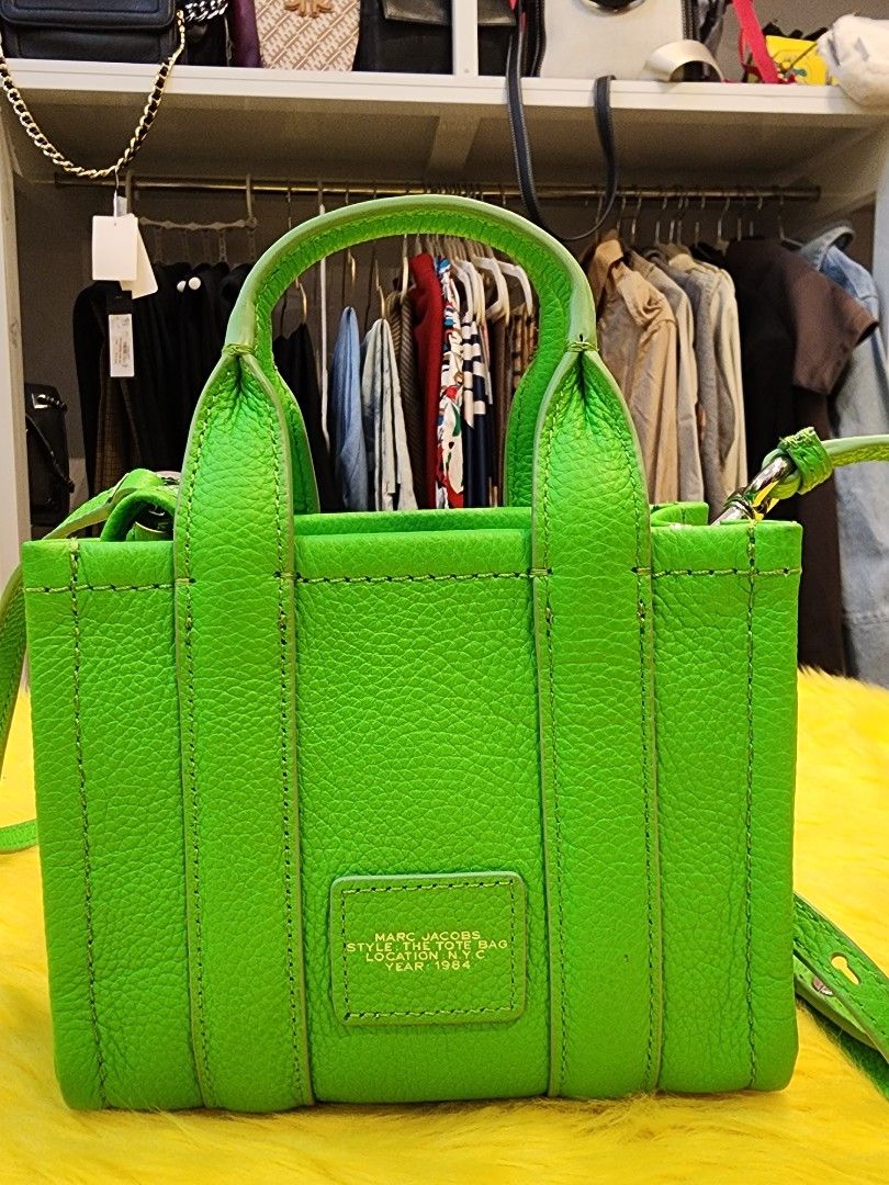 The mini TOTE BAGS by MJ (Category: Cross-body Bags) located in San Nicolas. Submitted by lapofluxuryatelier (Listing ID 1462191030, Image 2). Description: The Marc Jacobs Mini Tote Bag is a compact, highly versatile everyday statement accessory combining structured utility with casual, logo-mania chic. condition: slightly Used.