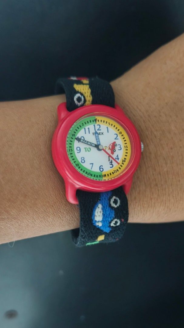 Timex Kids Watch Red with Fun Pattern Strap (Category: Babies & Kids Fashion) located in Taguig. Submitted by mercyeugen28914 (Listing ID 1462133543, Image 2). Description: - Cute Timex watch designed for kids. - Features a vibrant red casing. - Fun black strap with colorful cars and characters. - Easy-to-read dial with numbers for learning. - Water resistant for everyday adventures. - Adjustable strap for a comfortable fit. - Great for daily wea
