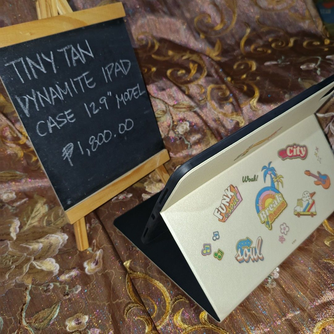 Tiny Tan Dynamite iPad Case for 12.9" Model (Category: Cases & Sleeves) located in Manila. Submitted by cypherchepark (Listing ID 1462232492, Image 2). Description: From 1,800.00 SALE to 1,400.00 only 💜 - Protect your 12.9" iPad with this adorable Tiny Tan Dynamite case. - Features all BTS members dressed in their iconic Dynamite outfits. - Includes a convenient stand function for hands-free viewing. - A must-have for any dedicated ARMY! - Price