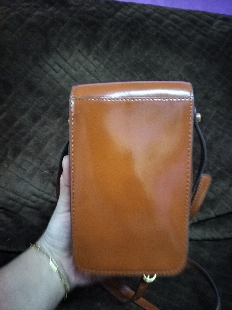 TORY BURCH ROBINSON SPAZZOLATO MOBILE BAG (Category: Luxury Bags & Wallets) located in Caloocan City. Submitted by jennielz (Listing ID 1462154418, Image 2). Description: Authentic TORY BURCH ROBINSON SPAZZOLATO MOBILE BAG -made in vietnam -coded -color sienna -no rubs -intact ruber linings flaw: small 2dots penmark. I don't know how to remove it. over all the bag looks like new..