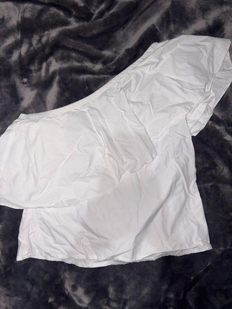 Twill Cavern White One Shoulder Ruffle Top Size S (Category: Sleeveless) located in Manila. Submitted by scoobydoo_clothing (Listing ID 1462211842, Image 1). Description: - White one-shoulder top - Brand: Twill Cavern - Size: S - Features a cute ruffle detail across the front - Elasticated hem for a comfy fit - Note: Small marks on the front, as shown in the last photo. - Still a great wardrobe addition!.