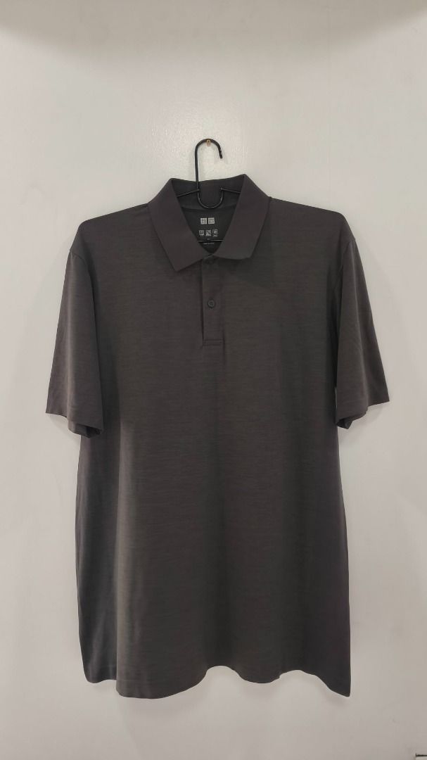 Uniqlo Polo Shirt (Category: Activewear) located in Quezon City. Submitted by secondtonone12 (Listing ID 1462044715, Image 1). Description: Brand: UNIQLO — the neck label appears consistent with the brand, although the photo does not establish authenticity. Style: Plain short-sleeve polo shirt. Color: Charcoal gray / dark gray. Collar: Structured polo collar with a two-button placket..