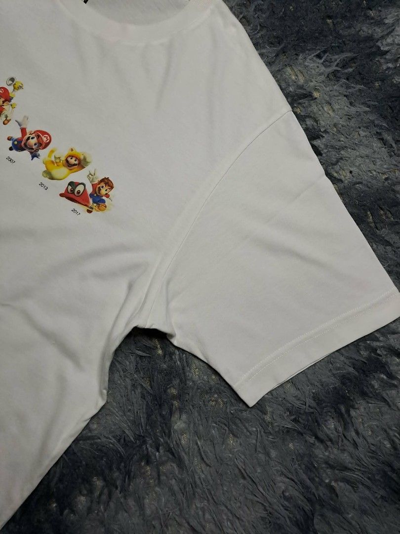 UT Uniqlo x Nintendo Mario Evolution (Category: Tshirts & Polo Shirts ) located in Manila. Submitted by yaseen__73 (Listing ID 1462216083, Image 2). Description: Uniqlo UT graphic t-shirt featuring a row of character sprites that show Mario's design evolution from 1985 to 2017 across the chest Wearing Size : Large on Tag Dimensions : See Photo Color Rate : 9.9/10 Flawless In Excellent Condition - PRE Owned MOP : G C A S H B A N K T R A N S F E R 