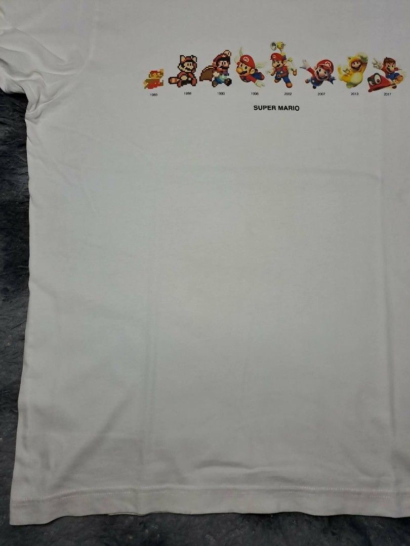 UT Uniqlo x Nintendo Mario Evolution (Category: Tshirts & Polo Shirts ) located in Manila. Submitted by yaseen__73 (Listing ID 1462216083, Image 3). Description: Uniqlo UT graphic t-shirt featuring a row of character sprites that show Mario's design evolution from 1985 to 2017 across the chest Wearing Size : Large on Tag Dimensions : See Photo Color Rate : 9.9/10 Flawless In Excellent Condition - PRE Owned MOP : G C A S H B A N K T R A N S F E R 