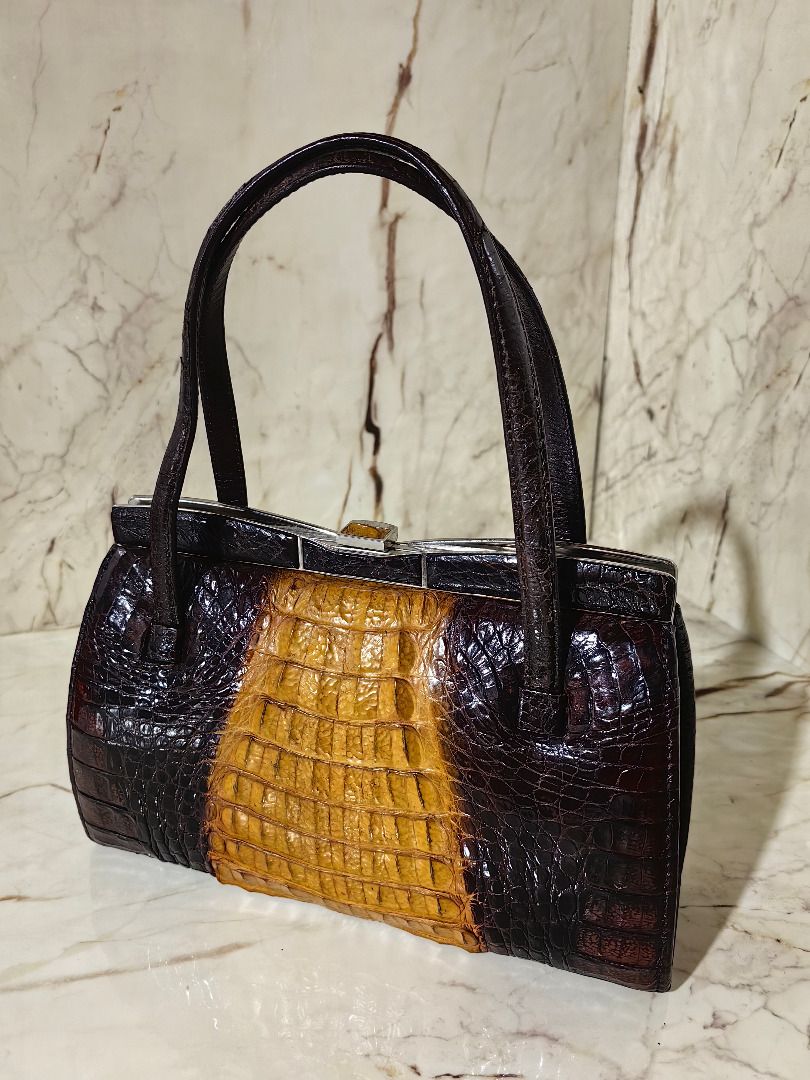 Vintage Crocodile Skin Handbag (Category: Luxury Bags & Wallets) located in Caloocan City. Submitted by jeremiah.curator.2026 (Listing ID 1462256656, Image 2). Description: - Genuine dark brown and tan crocodile skin - Unique color block design - Structured shape with secure clasp closure - Convenient top handles for carrying - Classic vintage statement piece.