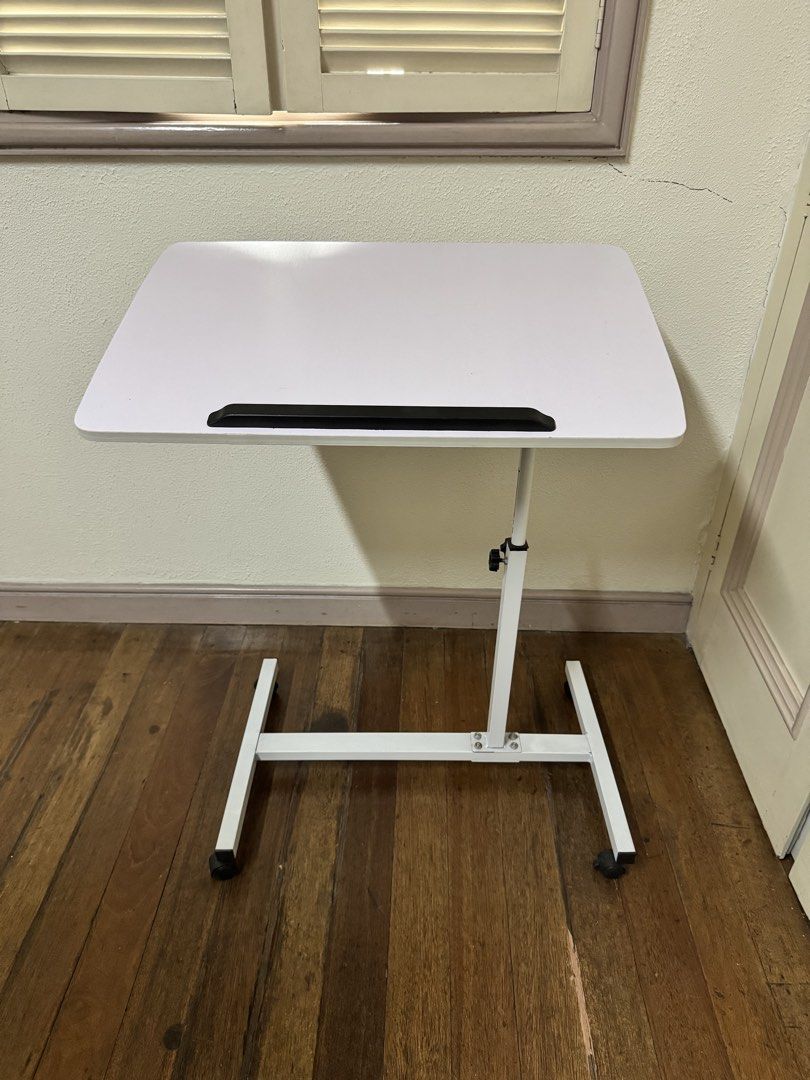 White Adjustable Laptop Table with Wheels (Category: Tables & Sets) located in Makati City. Submitted by avic_c (Listing ID 1462052191, Image 1). Description: - Adjustable height for personalized comfort - Tiltable top surface for optimal viewing angles - Built-in wheels for effortless mobility - Ideal for working comfortably on your bed or sofa - Compact design for easy storage Dimensions: 40 x 60 cm Reason: Decluttering .