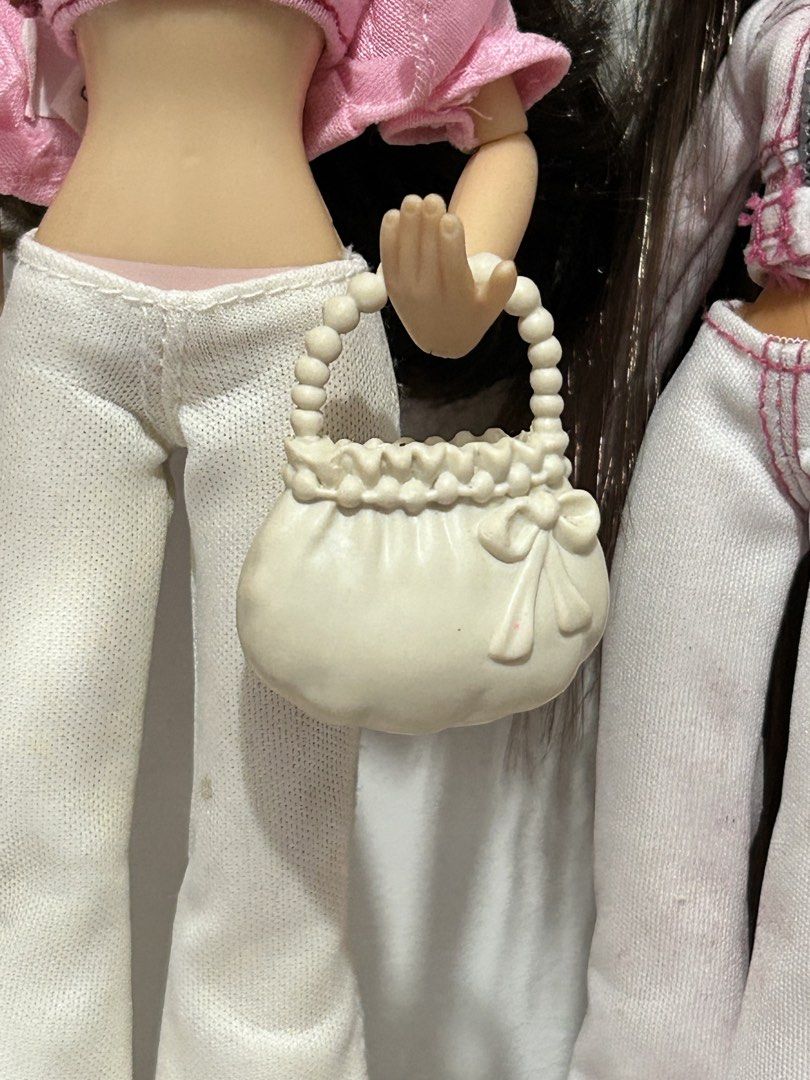 White Doll Handbag with Beaded Handle and Bow Detail (Category: Purses & Pouches) located in Batangas. Submitted by nommi26 (Listing ID 1462200577, Image 1). Description: - Adorable white handbag for dolls - Features a charming beaded handle - Decorated with a sweet bow on the front - Top edge has a delicate ruffled detail - Ideal accessory to complete any doll's outfit - Perfectly sized for small dolls needs cleaning.