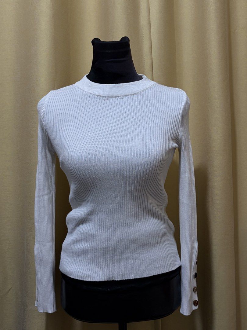White Ribbed Knit Sweater with Button Cuffs (Category: Longsleeves) located in Baguio. Submitted by fionabanana (Listing ID 1462114228, Image 1). Description: - White ribbed knit sweater - Long sleeves with button cuff details - Classic crew neck - Stretchy and comfortable material - Versatile: pairs perfectly with jeans or skirts.