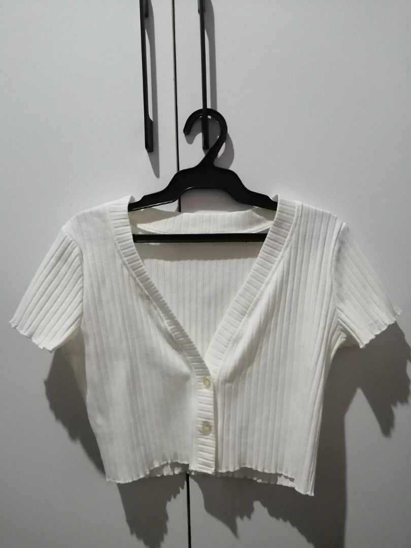 White Ribbed V-Neck Button-Up Cropped Cardigan (Category: Blouses) located in Santa Rosa. Submitted by ciacloset (Listing ID 1462124173, Image 1). Description: - Cute white cropped cardigan - V-neck with button-up front - Ribbed texture all over - Short sleeves - Raw hem detail - Versatile for layering or wearing on its own - Easy to style for casual or dressed-up looks.
