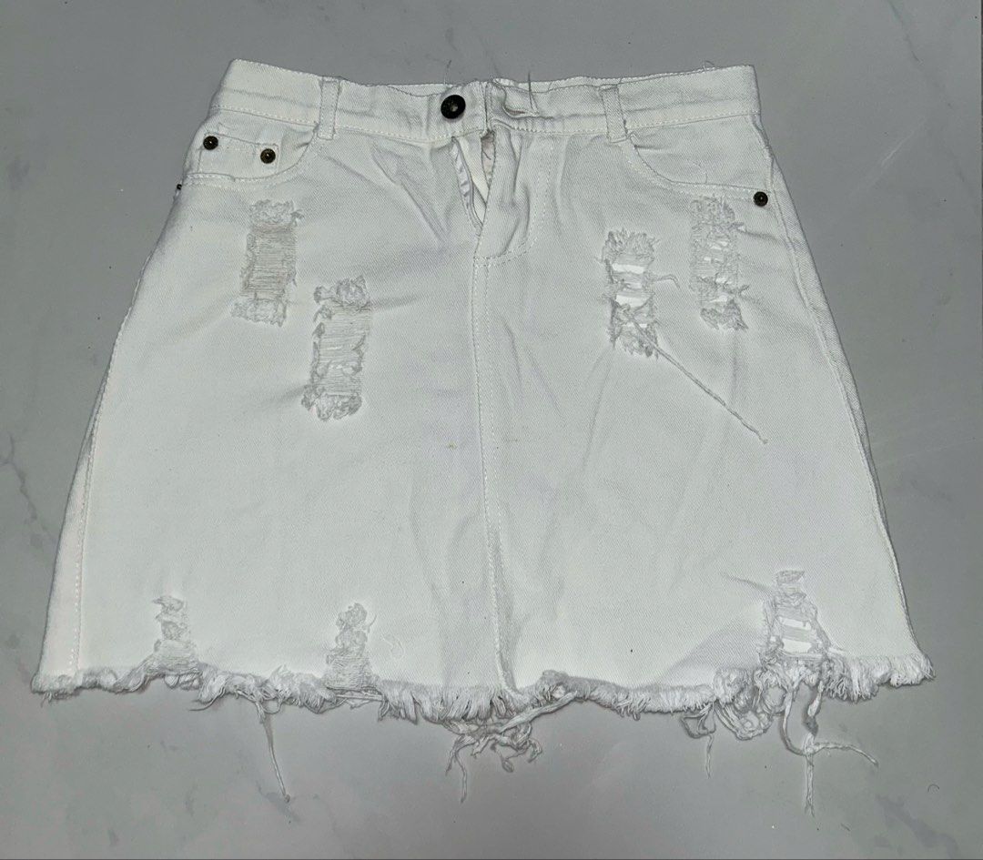 White Tattered Mini Skirt (Category: Skirts) located in Binan City. Submitted by xyz.closet (Listing ID 1462215910, Image 1). Description: • Has small stains on the front, and rips are asymmetrical due to usage • Fits XS or Small (Best for Waist 25–27 inches) but Medium on tag •Features a standard button-and-zipper closure • RFS: No longer fits me MOP: GCash or MariBank MOD: J&T or Lalamove — delivery fee will be shouldered by the buyer Reminders