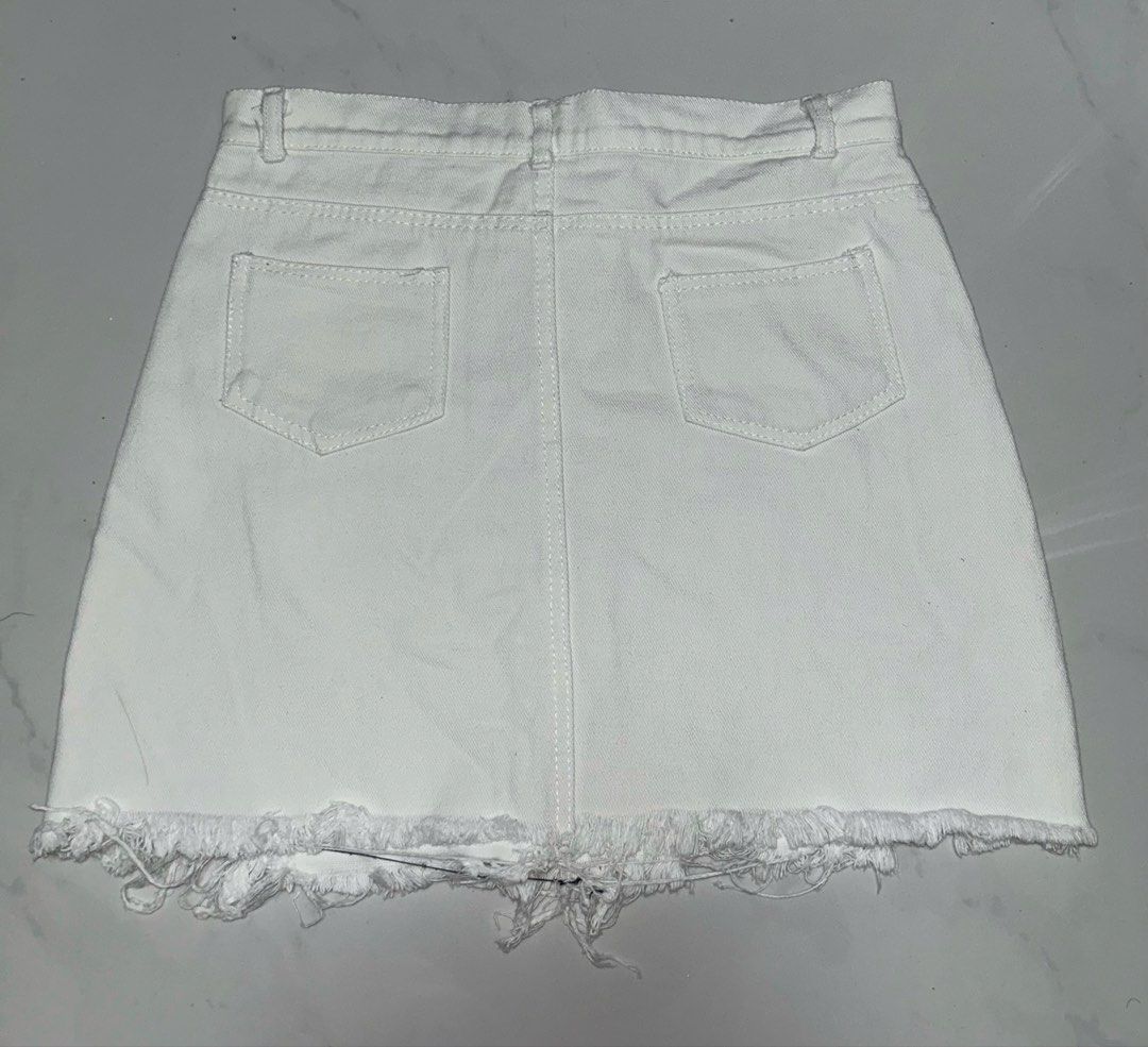 White Tattered Mini Skirt (Category: Skirts) located in Binan City. Submitted by xyz.closet (Listing ID 1462215910, Image 2). Description: • Has small stains on the front, and rips are asymmetrical due to usage • Fits XS or Small (Best for Waist 25–27 inches) but Medium on tag •Features a standard button-and-zipper closure • RFS: No longer fits me MOP: GCash or MariBank MOD: J&T or Lalamove — delivery fee will be shouldered by the buyer Reminders