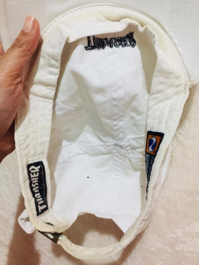 White Thrasher Newhattan Baseball Cap (Category: Caps & Hats) located in Baguio. Submitted by izza_thrifty (Listing ID 1462062836, Image 3). Description: - Brand: Newhattan - Design: White baseball cap with embroidered Thrasher logo - Material: 100% Cotton - Fit: One size fits most - Features: Adjustable strap at the back - Ideal for: Everyday wear.