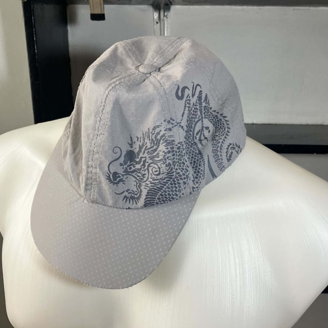 Y2K Breathable Perforated Grey Dragon Graphic Runner Cap (Category: Caps & Hats) located in Manila. Submitted by ninjadisplay (Listing ID 1462175621, Image 1). Description: * Brand: Unbranded / Generic * Style: Unstructured Runner Cap / Sporty Baseball Cap. Features a striking dark grey traditional dragon graphic printed across the front and side panels. * Material: Ultra-lightweight, breathable perforated micro-mesh fabric. Designed to keep your