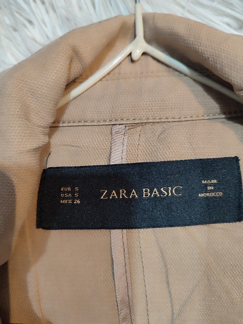 Zara Basic Beige Cropped Jacket (Category: Coats, Jackets and Outerwear) located in Manila. Submitted by momofunodos (Listing ID 1460176575, Image 2). Description: - Zara Basic beige cropped jacket - Classic trench coat style with lapels and shoulder details - Two functional front pockets - Cuffed sleeves with button detail - Ideal for layering and versatile styling (dress up or down).