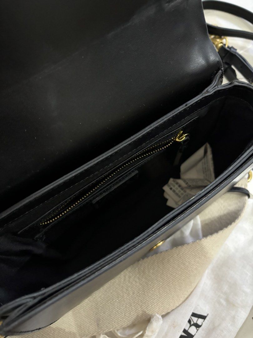 Zara Black Saddle Bag with Wide Strap (Category: Shoulder Bags) located in Bulacan. Submitted by janeeeeelleeeee (Listing ID 1462217826, Image 3). Description: Zara black saddle bag. Comes with a wide beige and black strap. Gold hardware details. Interior has a zip pocket. Dust bag included. I still have the tag. Mall-bought for 2595. May non-visible flaws na po (see photo).