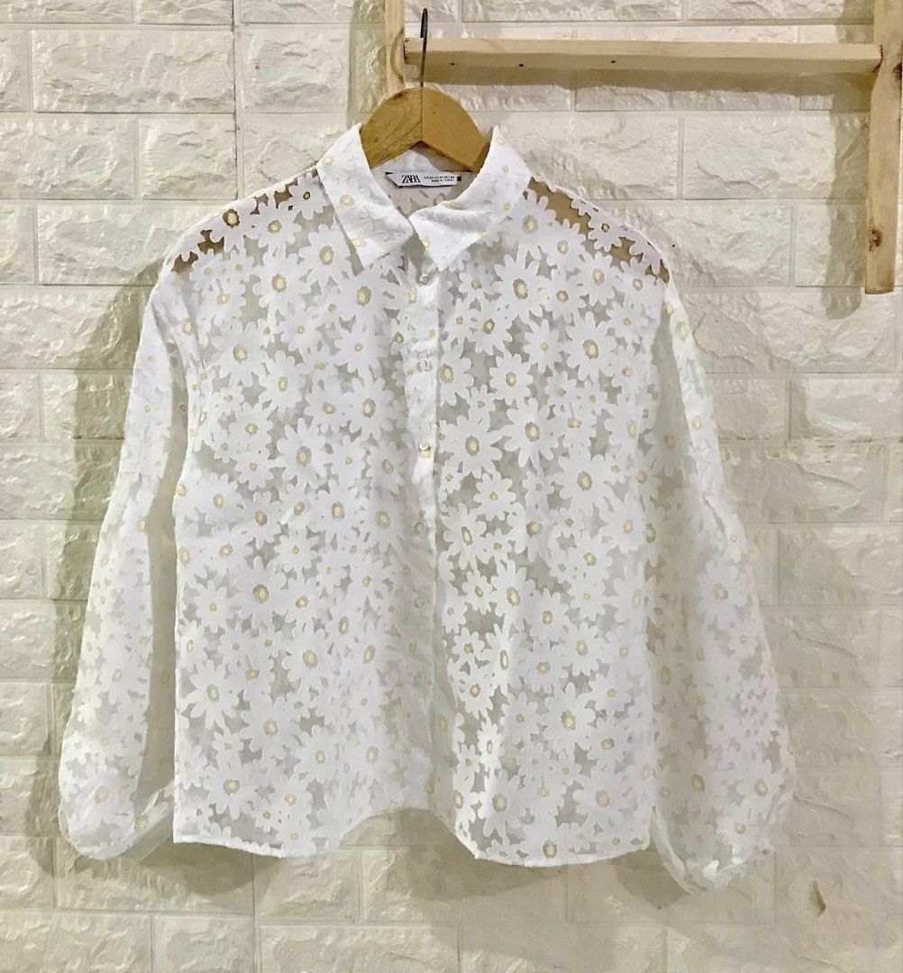 Zara White Daisy Lace Button-Up Blouse (Category: Blouses) located in La Trinidad. Submitted by rare_closet_finds (Listing ID 1462113572, Image 3). Description: - White sheer blouse -armpit to armpit 20” -length 22” - Daisy lace overlay; excellent condition - Button-up front with collar - Long balloon sleeves with elastic cuffs - Versatile: pairs well with pants or skirts - Delicate and pretty aesthetic.
