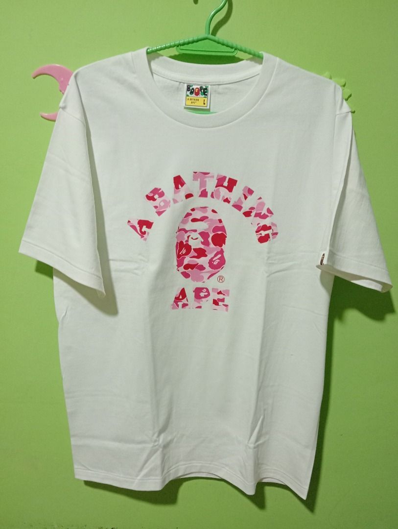A Bathing Ape BAPE Pink Camo Ape Head Tee (Category: Tshirts & Polo Shirts ) located in Caloocan City. Submitted by yazzielux (Listing ID 1462431893, Image 3). Description: - Authentic White A Bathing Ape T-Shirt - Features iconic pink camo Ape Head graphic - Arch logo across the chest - Comes in original packaging - Size: Large (L) - Essential piece for any streetwear collection.